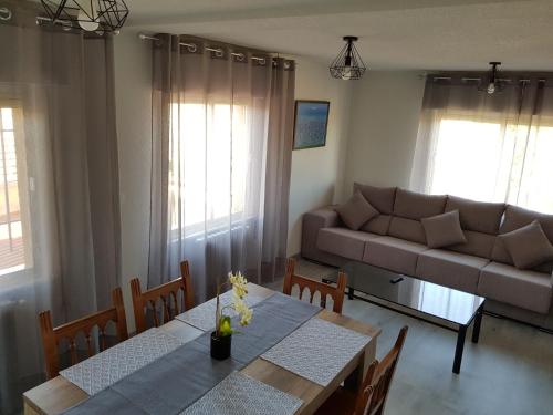 sala de estar con mesa y sofá en Vivienda Turística El Asturiano, en Montamarta