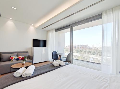 a bedroom with a large bed and a living room at Verde Apartments in Athens