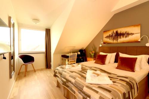 a bedroom with a large bed in a attic at Smygehus Havsbad in Smygehamn