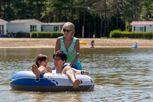 a woman and two people on an inner tube in the water at Vakantiepark Breebos in Rijkevorsel