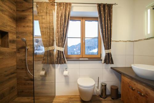 a bathroom with a toilet and a glass shower at Riederhof in Ruhpolding