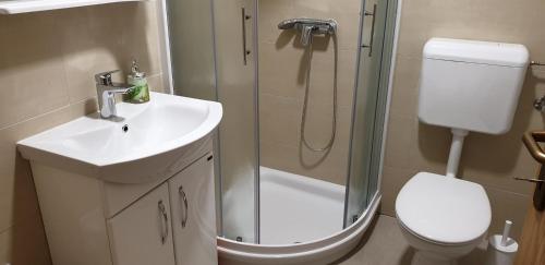 een badkamer met een douche, een wastafel en een toilet bij White Apartment in Izola