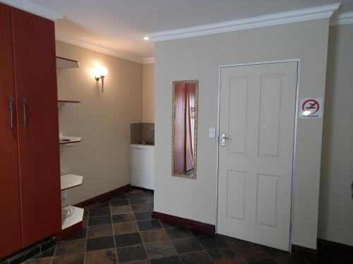 a bathroom with a white door and a toilet at Troas Boutique hotel in Vanderbijlpark