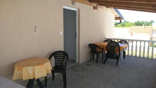 een veranda met een tafel en stoelen op een balkon bij Apartments Ninske Vodice in Nin