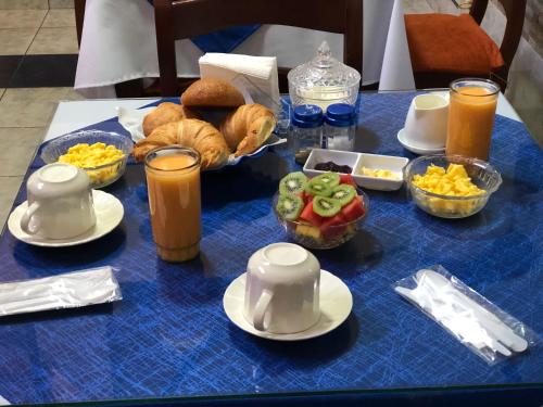 a blue table with breakfast foods and drinks on it at Hotel Casa Santa Lucía in Baños