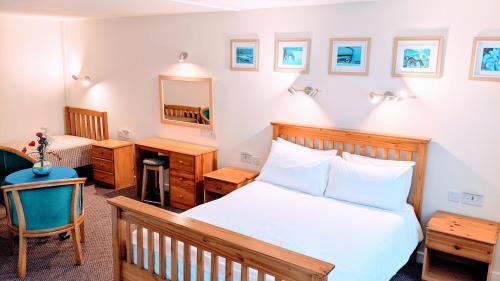 sypialnia z łóżkiem, biurkiem i lustrem w obiekcie Ivybridge Guesthouse w mieście Fishguard