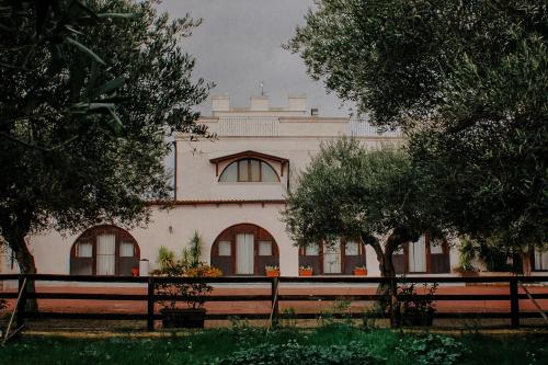 a white building with trees in front of it at B&B Villa Flora in Santeramo in Colle