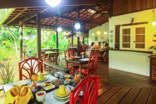 a restaurant with a table and chairs and people eating at Pousada Horizonte Azul in Ilha de Boipeba
