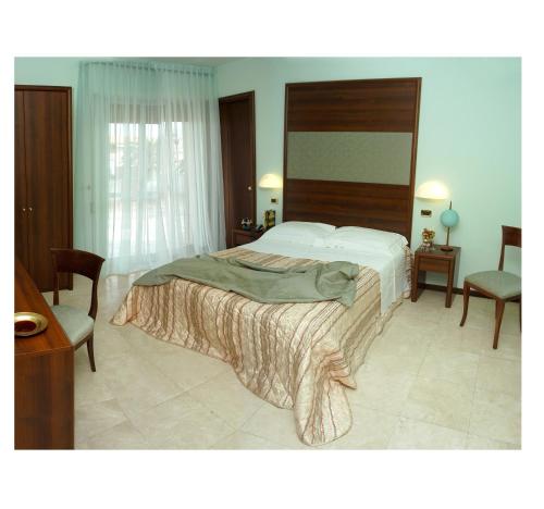 1 dormitorio con 1 cama grande y 2 sillas en Hotel Royal, en Vasto