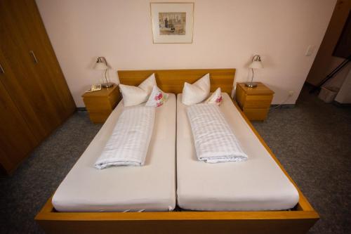 two beds with white pillows on them in a room at Kaiserstühler-Hof in Breisach am Rhein