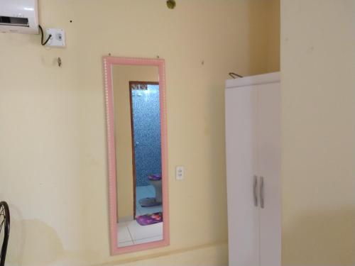 a bathroom with a pink mirror on the wall at Chalé da Kikia in Icapuí