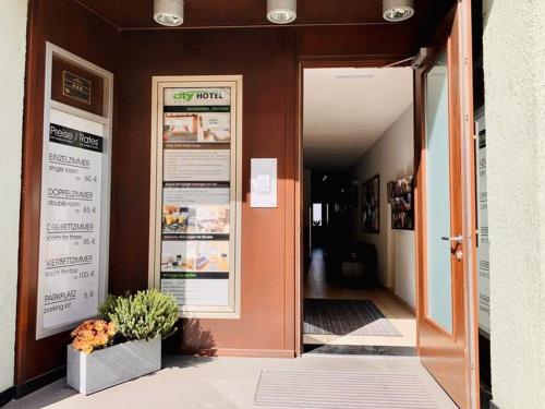 an open door to a restaurant with flowers in front at City Hotel in Eisenach