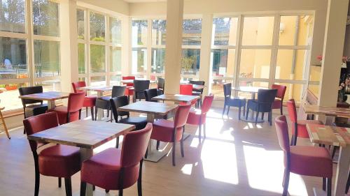 a restaurant with tables and chairs and windows at Hôtel La Bérangère in Pérouges