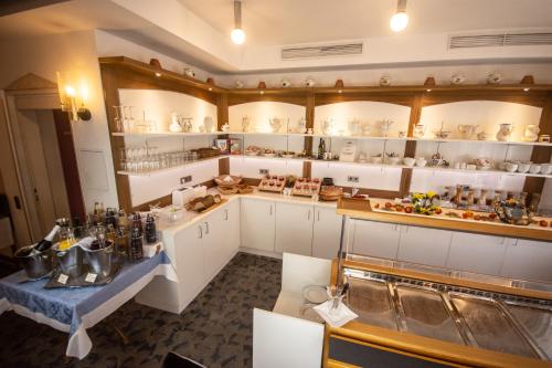 a kitchen with white cabinets and a counter with dishes at Kaiserstühler-Hof in Breisach am Rhein