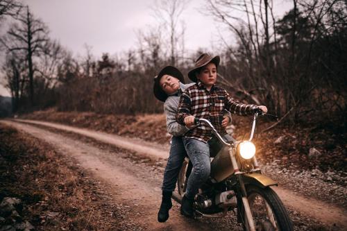 two boys riding a motorcycle on a dirt road at Tmbin's barn - nature, horses, family in Sežana