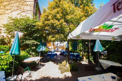 a patio with umbrellas and tables and chairs at Kaiserstühler-Hof in Breisach am Rhein