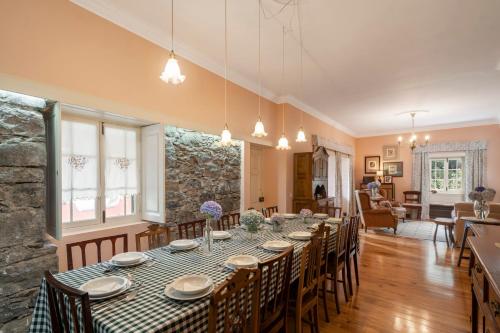 una sala da pranzo con un lungo tavolo e sedie di Casas do Lanço by An Island Apart a São Vicente