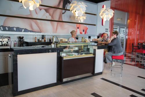 a group of people sitting at a counter in a restaurant at Riu Palace Aruba - All Inclusive in Palm-Eagle Beach