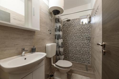 uma casa de banho com um WC, um lavatório e um chuveiro em Apartman Pandula em Tkon