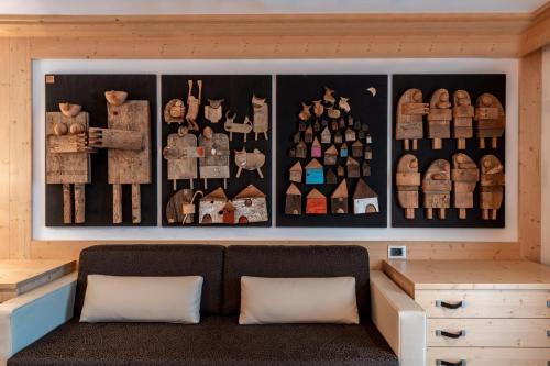 a room with a couch and a wall of figurines at Croce Bianca Leisure & Spa Hotel in Canazei