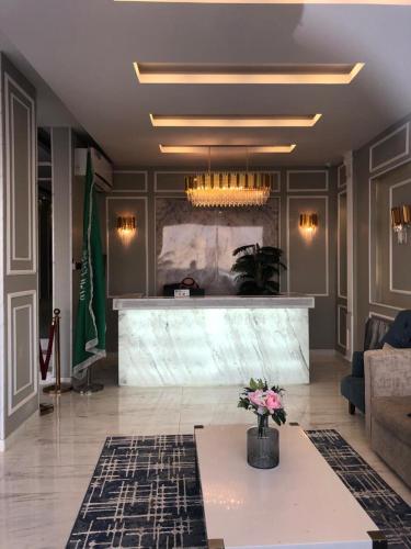 una sala de estar con un vestíbulo con una mesa con flores en Marina Arar Furnished Apartments, en Arar