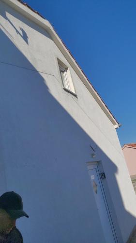 a man standing in front of a white house at Apartments Michael & Petra , Omisalj, Insel Krk, Kroatien in Omišalj