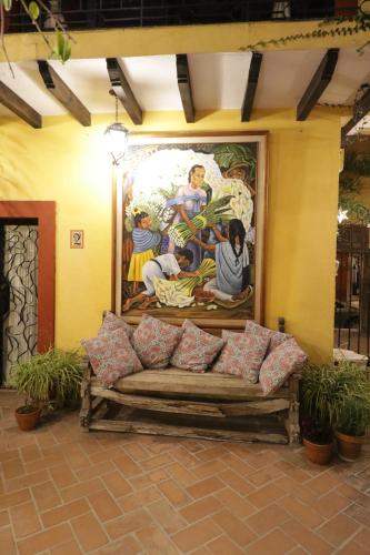a couch sitting in front of a wall with a painting at Casa Mia Suites in San Miguel de Allende