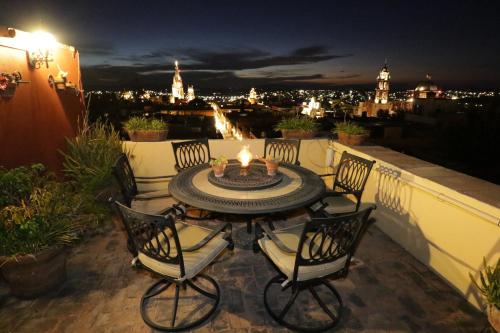 a table and chairs on a balcony at night at Casa Mia Suites in San Miguel de Allende