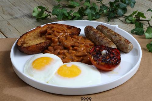 a plate of breakfast food with eggs sausage and beans at SHIRVAN Hotel City Yard Jeddah in Jeddah