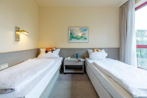 two beds in a room with a window at Hotel Baden-Baden in Baden-Baden