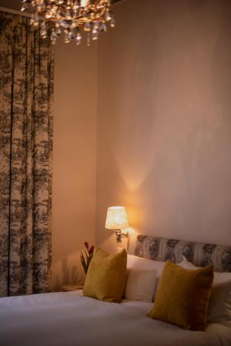 a bedroom with a bed with a lamp and a chandelier at Cape Heritage Hotel in Cape Town