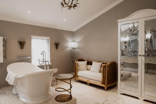 a bathroom with a tub and a chair in a room at Cape Heritage Hotel in Cape Town
