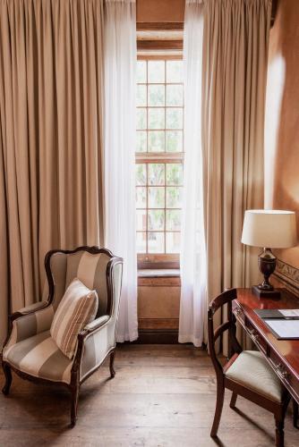 a room with a chair and a desk and a window at Cape Heritage Hotel in Cape Town