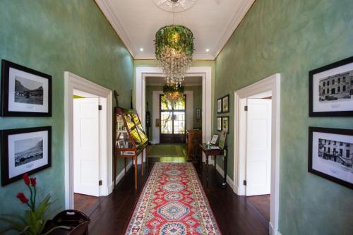 a hallway with green walls and a chandelier at Cape Heritage Hotel in Cape Town