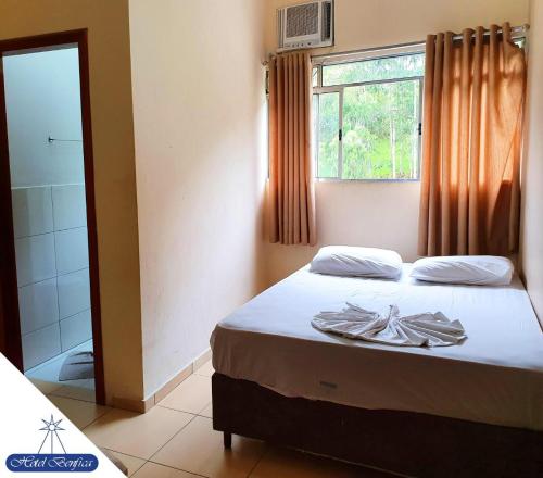 a bedroom with a bed and a window and a shower at Hotel Benfica in Aparecida
