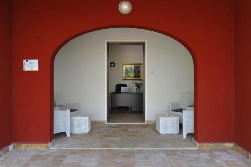 an archway in a room with a red wall at Agriturismo Caranna in Torre Lapillo