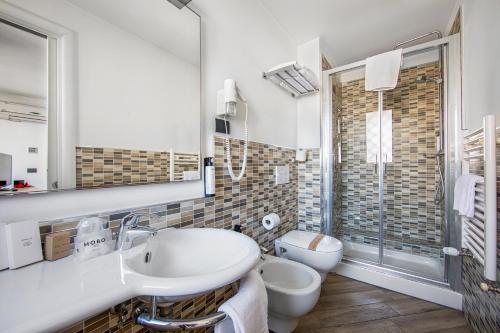 Baño blanco con lavabo y aseo en Borgo Aureo, en Roma