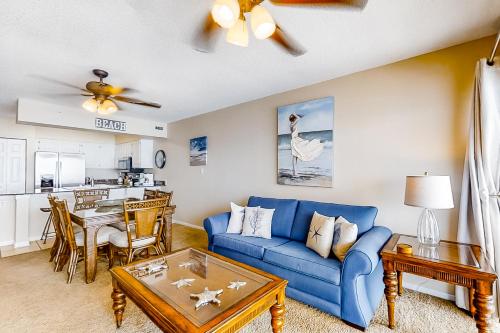 sala de estar con sofá azul y mesa en Emerald Towers en Fort Walton Beach