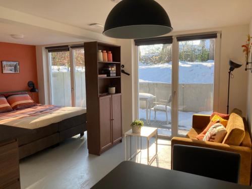 a bedroom with a bed and a living room at B&B 't Onderkomen in 't Harde