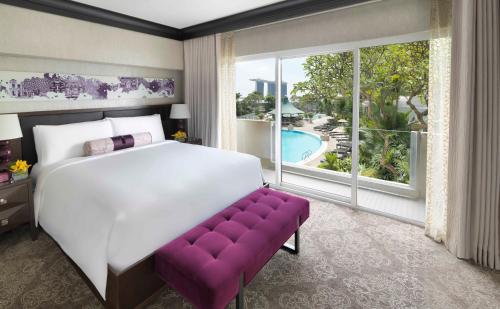 a bed sitting in a bedroom next to a window at Fairmont Singapore in Singapore