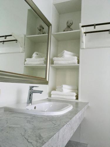 a bathroom with a sink and a mirror and towels at Bonnie's Beachhouse - villa aan zee in De Panne