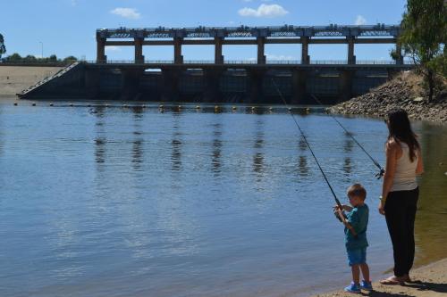 a woman and a child fishing in the water at Yarrawonga Holiday Park in Yarrawonga