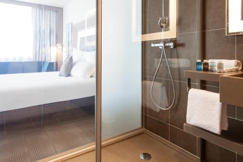 a shower with a glass door in a bathroom at Novotel Toulouse Centre Wilson in Toulouse