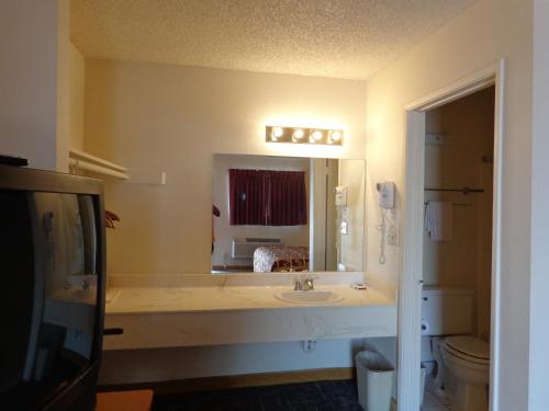 a bathroom with a sink and a large mirror at Knights Inn Phoenix at N Black Canyon Hwy in Phoenix