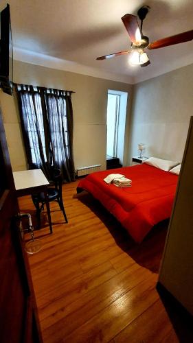 a bedroom with a red bed and a ceiling fan at Hotel Positano in Mar del Plata