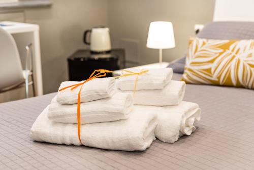 una pila de toallas sentadas encima de una cama en 5 terre dei poeti en La Spezia
