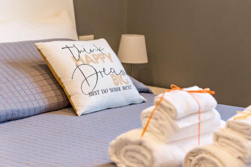 a pillow that says happy new year next to towels on a bed at 5 terre dei poeti in La Spezia