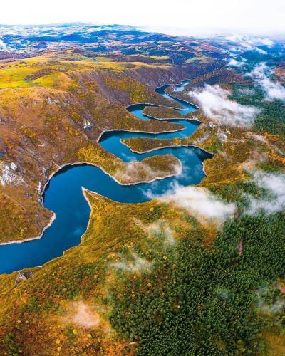an aerial view of a river in a field at Log cabin Uvac (Vikendica Saponjic) in Nova Varoš