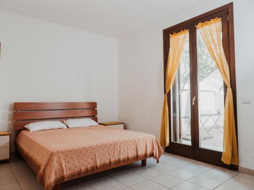 a bedroom with a bed and a sliding glass door at APPARTAMENTO SPECCHIO D'ACQUA in Marittima