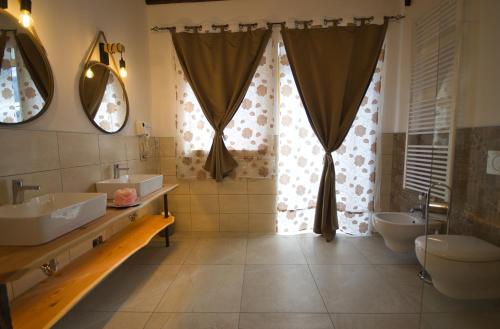 a bathroom with two sinks and two toilets at B&B Paganella Flabbi's Family in Spormaggiore